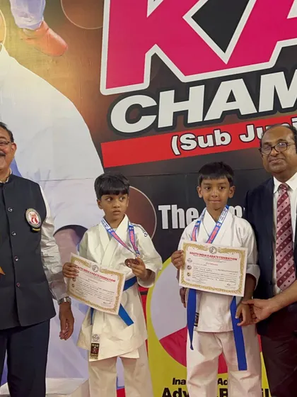 Two of our students proudly displaying their certificates and medals on the podium.