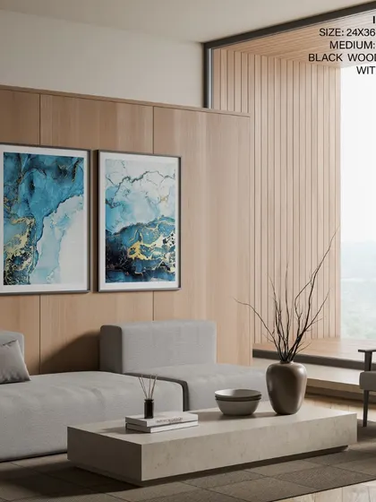 Our set of two indigo and gold abstract prints, shown in a modern living room with black frames. The combination of sleek frames and wood paneling creates a sophisticated and contemporary backdrop.