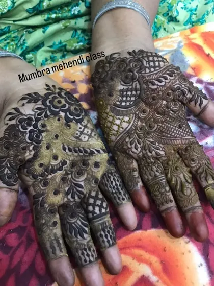 A party mehendi design with dense peacock and floral motifs.