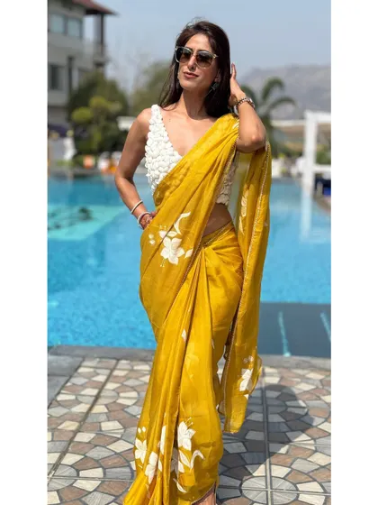 Posing by the pool, this image highlights the vibrant mustard yellow of the saree against the blue water. It’s a perfect color choice for a sunny, outdoor event.