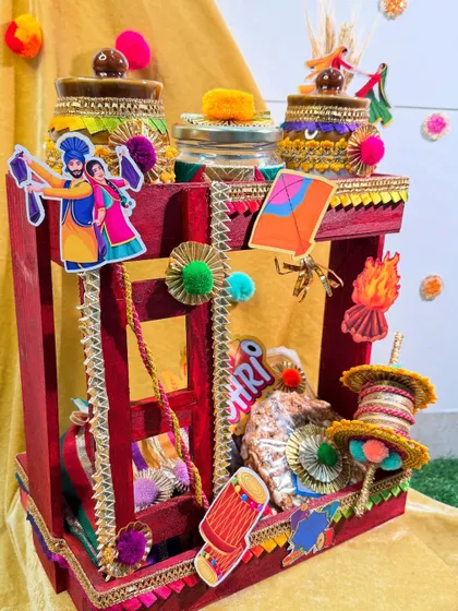 This grand Lohri hamper is designed like a traditional Punjabi manji (cot). It's a stunning centerpiece filled with decorated jars of winter treats.