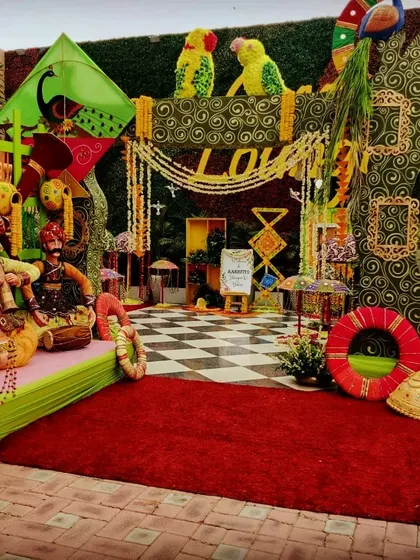 The main photo booth for a Teej party, showcasing a rich tapestry of colors and traditional Rajasthani decor elements, including puppets and kites.