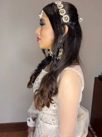 A side profile of Yutika's wedding guest look. You can see the details of the hair accessories and the beautiful, curled hairstyle.