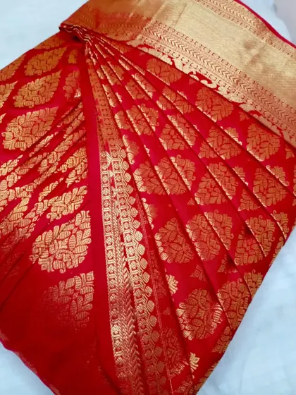 A classic red Banarasi saree with all-over gold work. The pleats are done to enhance its richness and make it easy to drape.