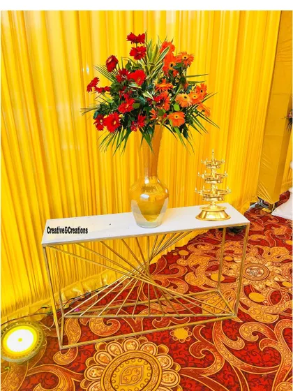 A decorative console table with a floral arrangement and a traditional brass lamp. These small details add to the overall richness of the decor.