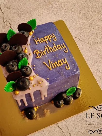 This purple cube cake is one of my favorite modern designs. It's a half-kg Lemon Blueberry Cream Cheese cake with a sharp, square shape, a delicate drip, and fresh blueberry decorations.