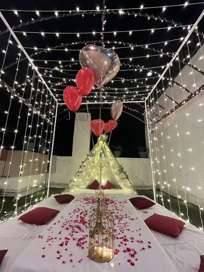 Another view of the romantic cabana, showing the table scattered with rose petals and heart-shaped balloons, perfect for a private dinner celebration.