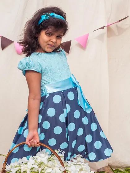 A full view of the blue polka dot dress, showing how the light blue top complements the darker skirt.