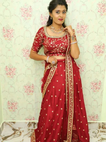 A full-length standing view of the maroon floral lehenga set, a perfect ethnic dress rental for weddings.