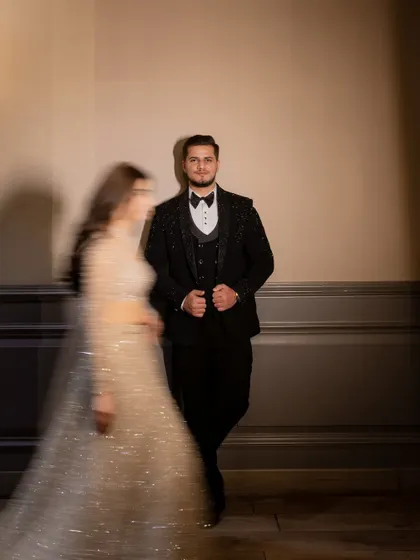 An artistic motion-blur photo, focusing on the groom while the bride moves past, creating a dynamic and modern engagement portrait.