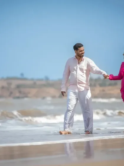 A beautiful, wide shot of a couple walking hand-in-hand on the beach during their pre-wedding shoot. This image captures the feeling of starting a new journey together.