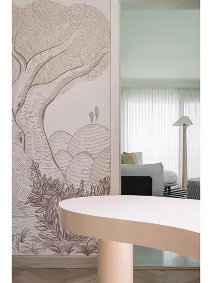 A detail of the family lounge, with a patterned carpet, mint green walls, and a sculptural armchair.