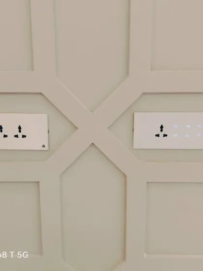 This image showcases a side-by-side installation of a standard switchboard and one of our smart touch panels. It illustrates how our solutions can be integrated alongside traditional fixtures within the same design scheme.