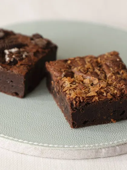 Fudgy, gooey, and irresistible. Here are two of our most popular brownie varieties: Creamy Oreo and a classic Walnut brownie.