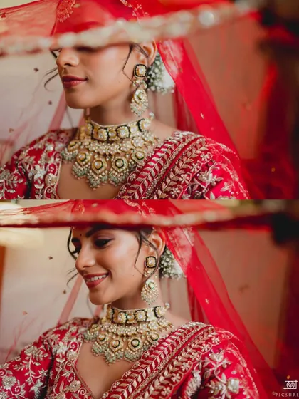 A close-up of a bride peeking through her red veil, her smile and beautiful jewelry highlighted in this intimate portrait.