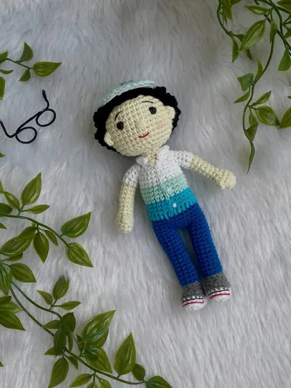 This handsome little boy replica doll features curly hair, a cap, and removable glasses. It’s so fun to create these little details that make each doll a true mini-me.