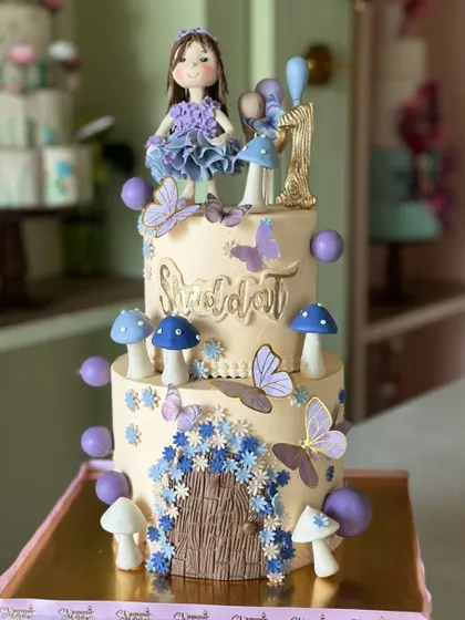 A little magic, a sprinkle of flowers, and a whole lot of love. This fairytale first birthday cake features a whimsical fairy door, delicate butterflies, and magical mushrooms.