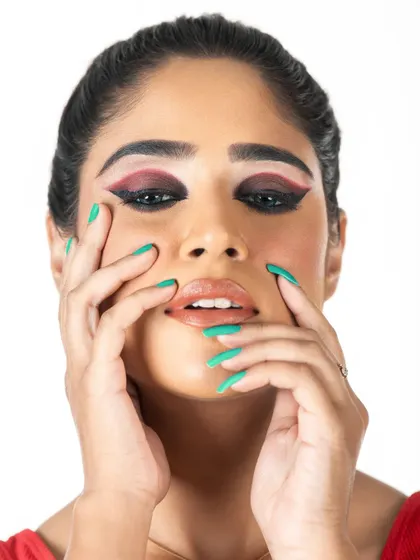 Another angle of the graphic eyeliner look, showing the sharp lines and color contrast. The skin is kept fresh and dewy with a glossy nude lip to let the eye makeup shine.