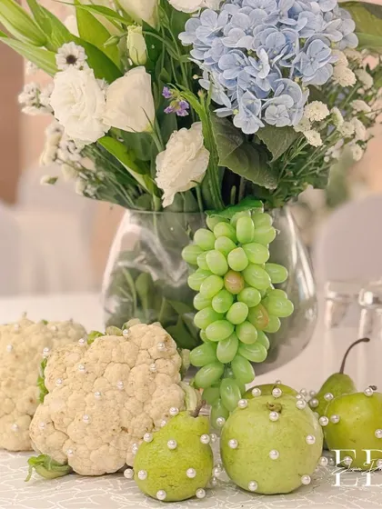 A truly unique centerpiece from the Sehrabandi, where cauliflower and pears adorned with tiny pearls are arranged with grapes and a bouquet of white and blue flowers. This is turning nature into art.