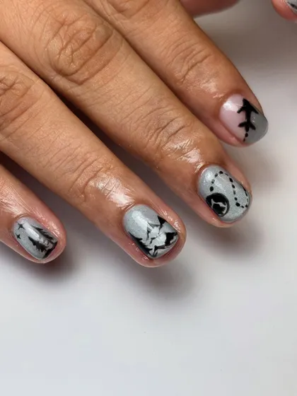A detailed shot of the Switzerland travel nails, showing the tiny airplane icon and the dotted flight path design. It's all in the little details.