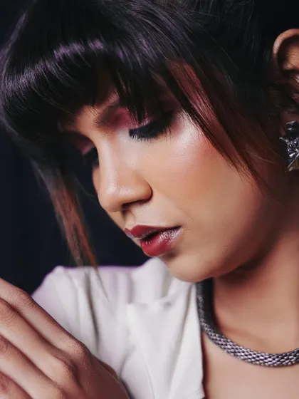 A delicate, soft-focus portrait. This pose highlights the makeup and the intricate details of the model's expression.