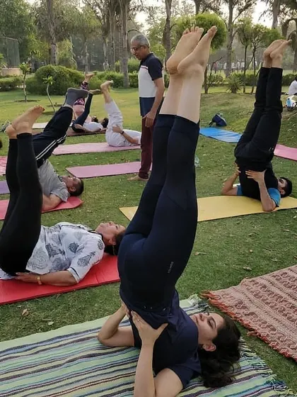 Students practicing Sarvangasana (Shoulder Stand) during our outdoor event. This inversion is known as the "queen of all asanas" for its wide-ranging health benefits.