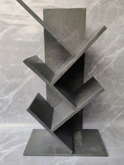 The grey marble bookshelf, pictured empty to showcase its unique, angular design. Its minimalist aesthetic fits perfectly in a modern home or office.