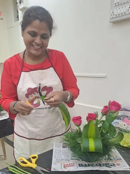 The joy of creation is visible on this student's face as she carefully adds foliage to her design. Our classes emphasize hands-on practice, allowing every student to develop their skills and personal style with confidence.