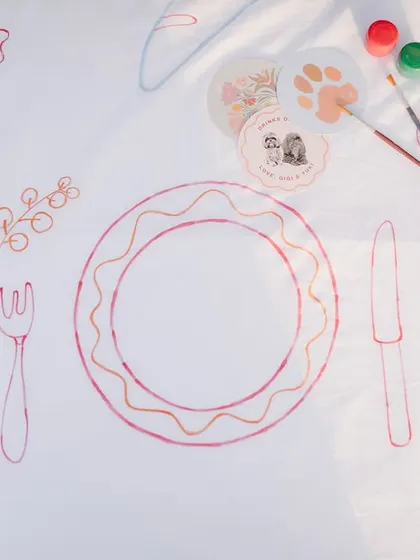 A detail of the custom-illustrated table runner, showing drawings of food and cutlery.