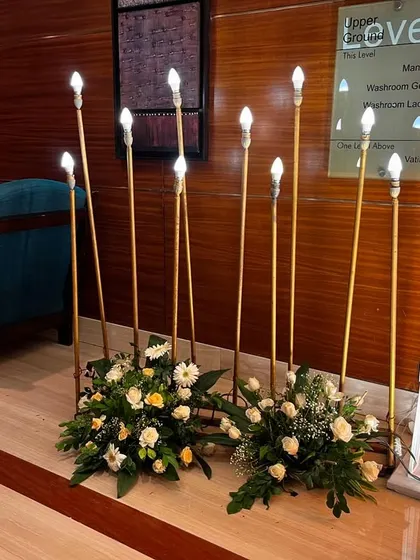 A detail shot of the modern floor lamps used to light the entrance pathway. These are paired with small floral arrangements to soften the look.