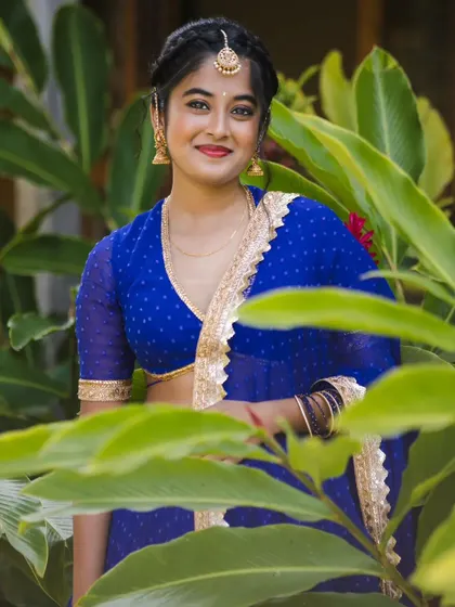 A close-up of the simple V-neck blouse with sheer sleeves, paired with the royal blue dotted lehenga. This minimalist design keeps the focus on the beautiful color and the bride's natural glow.