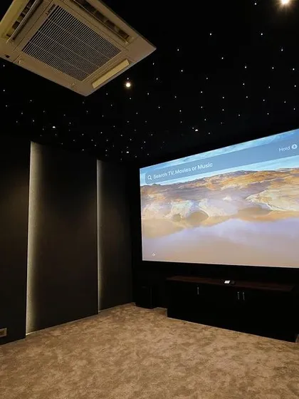 The large screen is the centerpiece of this room, perfectly framed by acoustically treated walls. This setup is ideal for enjoying high-definition content from streaming services like Apple TV.