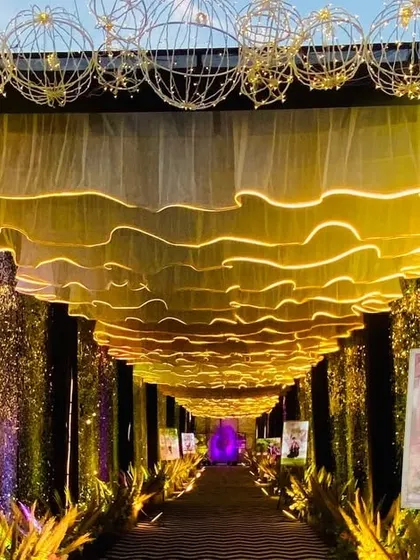 A closer look at the modern sequin and gold entrance, showing the details of the illuminated wavy ceiling and the custom photo displays.
