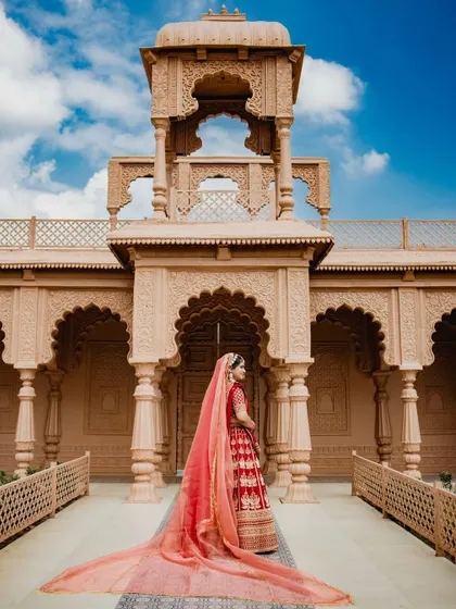 A breathtaking bridal portrait with a long, flowing veil against a magnificent architectural backdrop. This shot is the epitome of royal elegance and grandeur.