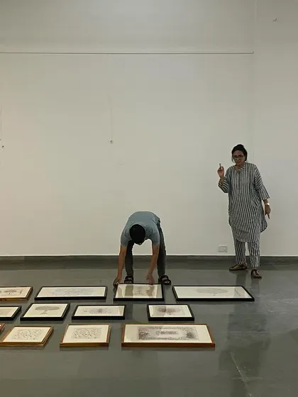 Curator Pushpamala N directing the installation of 'Hand Prints'.