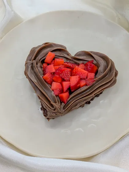 A mini heart-shaped treat for your love. This dessert features a rich chocolate base filled with freshly chopped strawberries and piped with a border of creamy Nutella frosting.