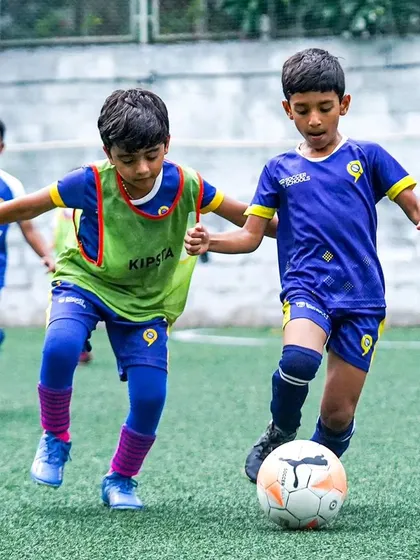 Two young players challenge for the ball, showing great determination. The future of football is bright.