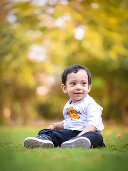 A simple, beautiful portrait of Avyan sitting on the grass during his first birthday outdoor shoot. Sometimes, the simplest moments are the most powerful.