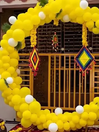 This outdoor Haldi setup features a large crescent-shaped balloon arch in yellow and white. I added traditional colorful hangings to the arch, blending modern balloon art with classic Indian decor elements.