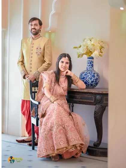 A regal and elegant portrait of the couple. The groom stands while the bride is seated, creating a classic, formal composition that feels timeless.