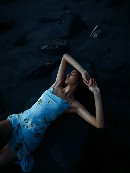 An expressive pose captured during the "blue hour" on the beach. This type of lighting is perfect for creating moody and atmospheric fashion shots.