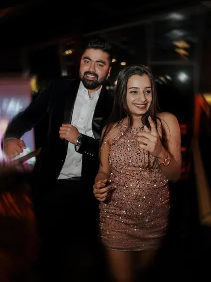 A candid shot of the couple dancing together at their cocktail party, their smiles radiating happiness.