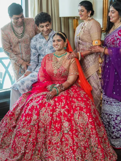 Getting the whole family together for a photo is a beautiful moment. I styled each member to complement the bride's stunning red lehenga, ensuring their outfits worked together harmoniously. It was a challenge, but seeing them all together, looking so happy, was worth it.