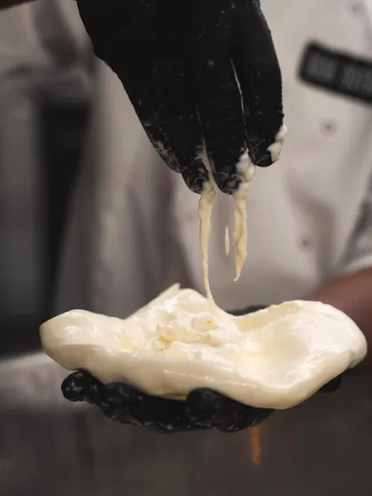 This is stracciatella, the creamy, stringy filling for our burrata. It's made by shredding fresh mozzarella and mixing it with cream, creating an incredibly indulgent texture.