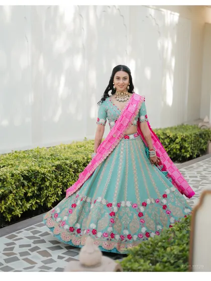 A full-length shot capturing the beautiful twirl of the bride's lehenga. The movement and vibrant colors create a dynamic and joyful portrait.