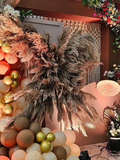 A close-up of the pampas grass arrangement from a boho-themed 30th birthday. The feathery textures, combined with the warm-toned balloons, create a soft and dreamy photo backdrop.