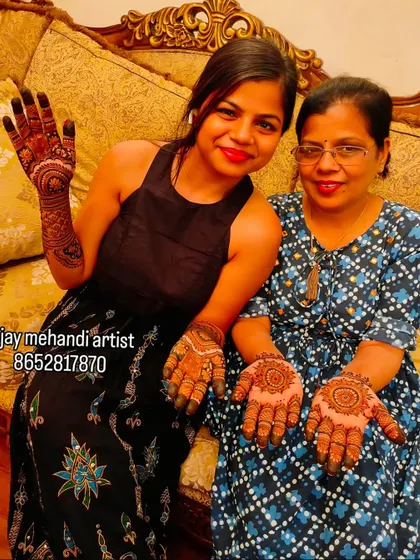 Happy clients are our best advertisement. We love when guests proudly show off their finished henna designs, one with a full-hand traditional pattern and the other with a classic mandala.