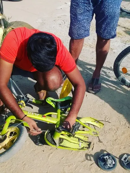 A father repairs his child's small bicycle, showing that repair skills are for everyone. It's a great way for parents to teach their kids about maintenance and self-sufficiency.