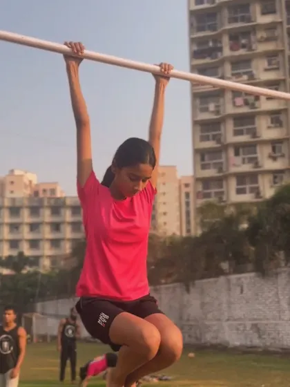 Perfecting her form on the bar. Each session brings her closer to her goal of mastering pull-ups and other skills.