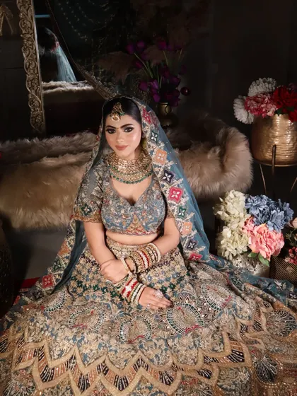 This seated portrait showcases the full grandeur of the bridal lehenga and the way the makeup ties the entire look together.